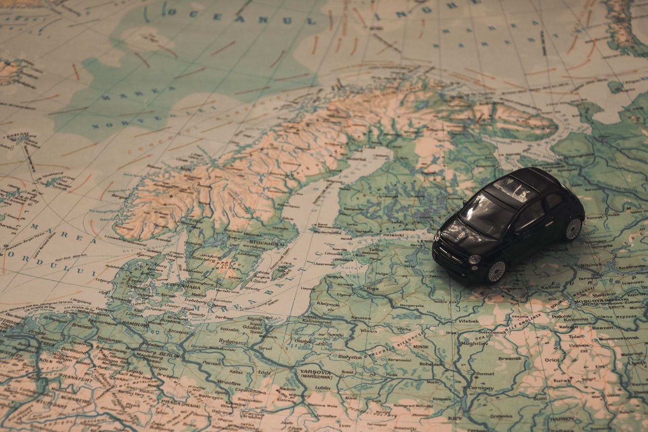 A miniature black car on a detailed map of Scandinavia, symbolizing travel adventures.